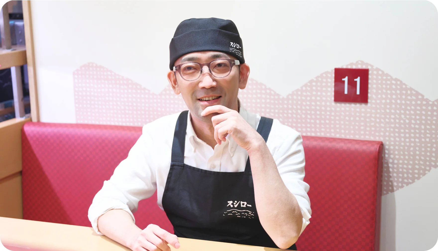客席のソファ席で笑顔で話す山原晋